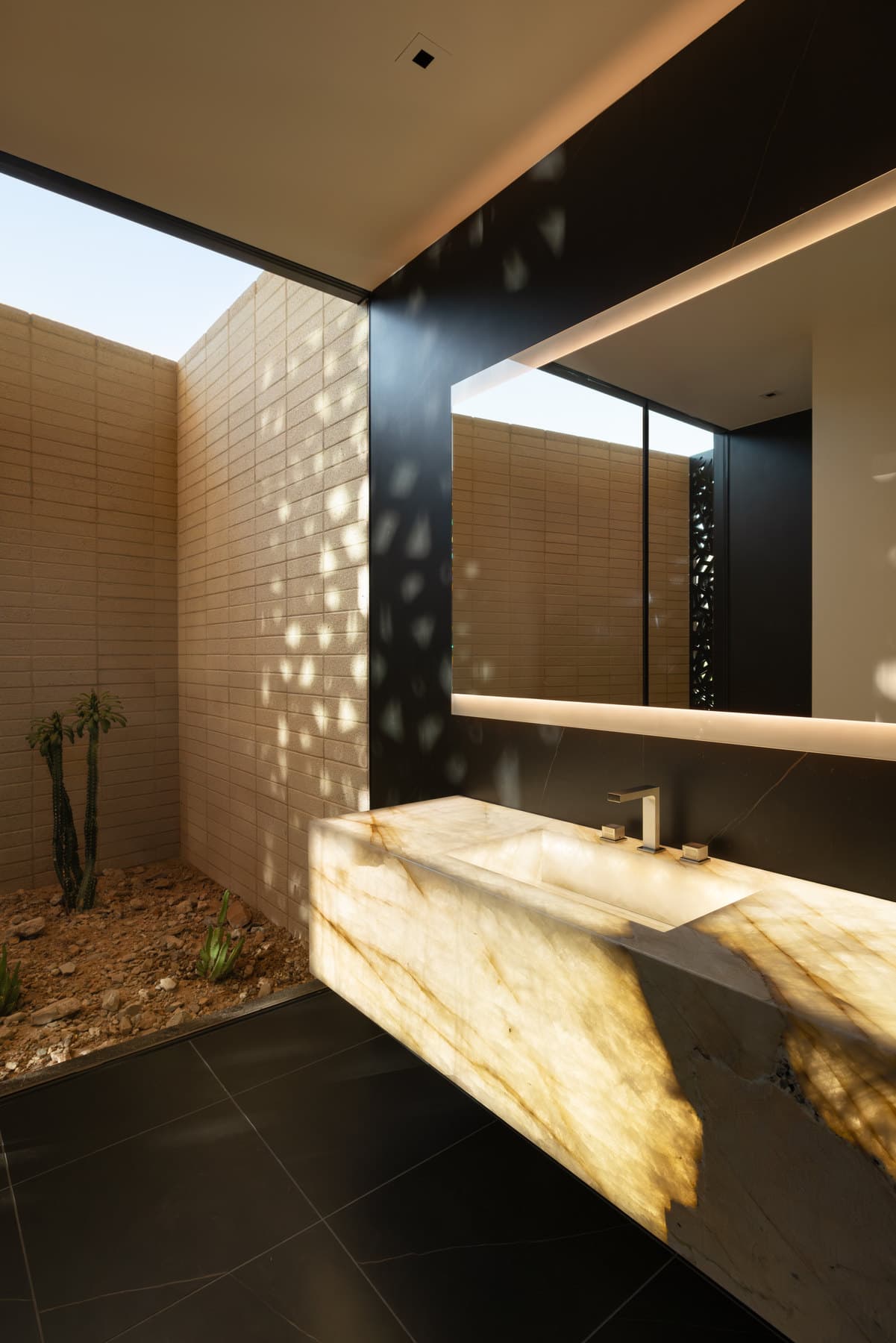 A backlit onyx basin under dappled light