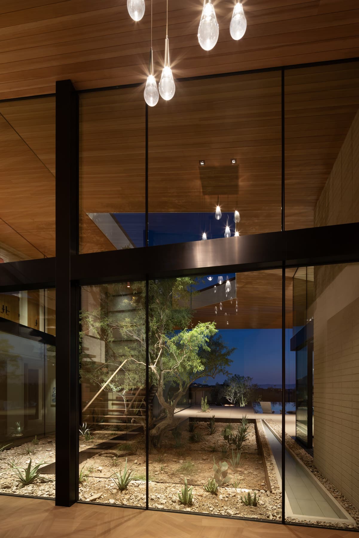 Pendant lights over the entry glass at dusk