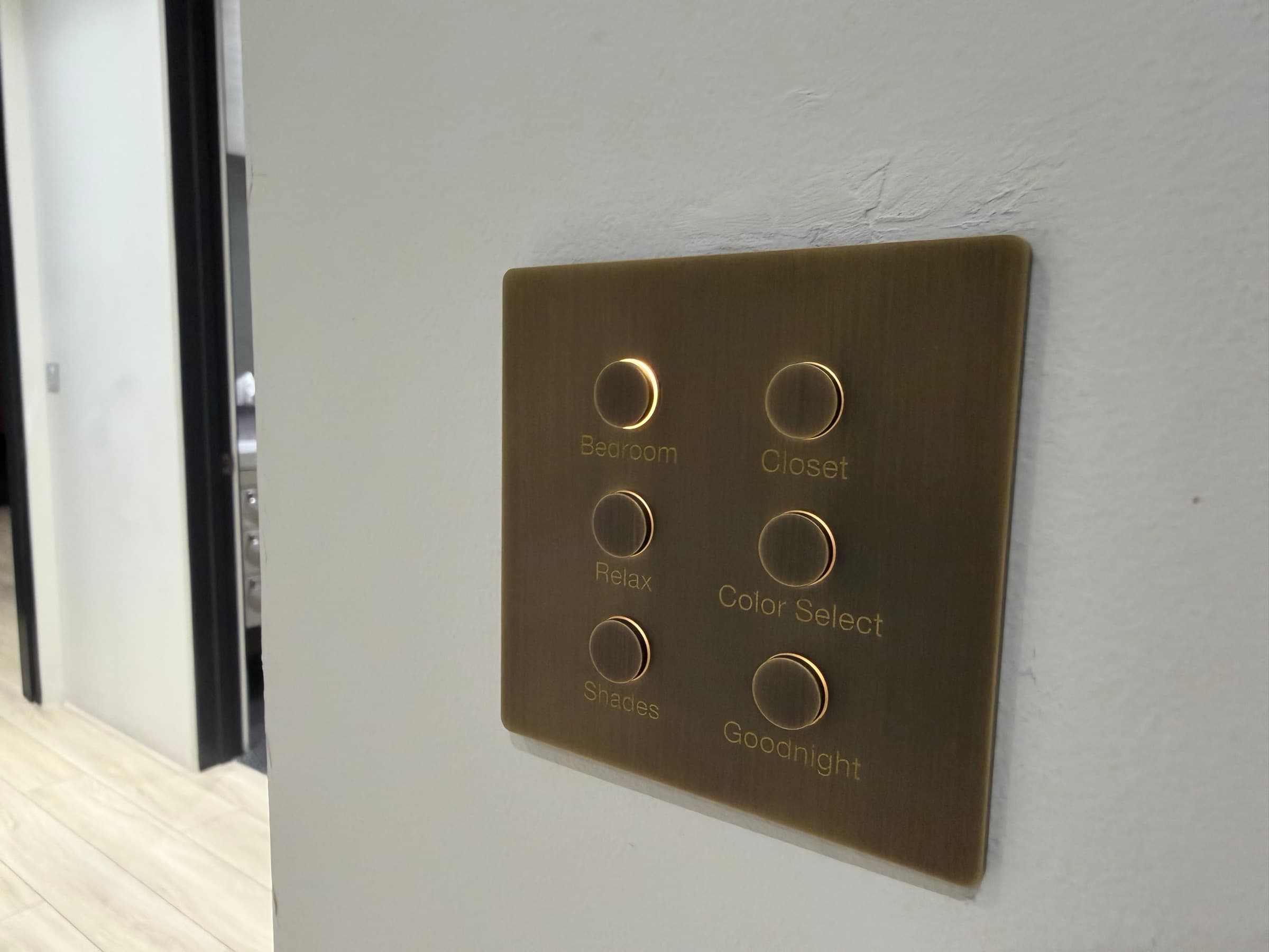 An antique brass lighting keypad with engraved scene buttons