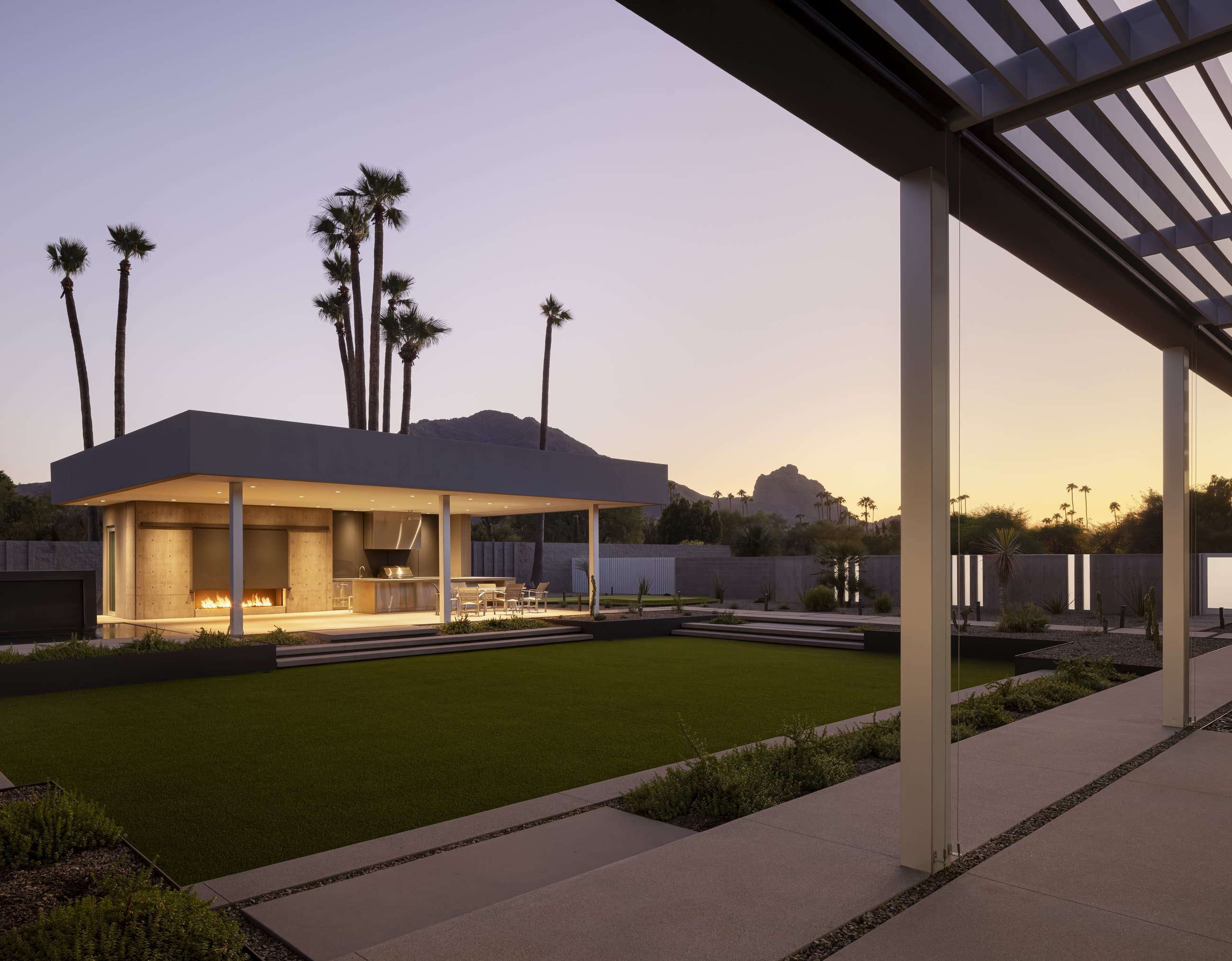 The White Wing residence at dusk, the pavilion lit beneath its louvered canopy