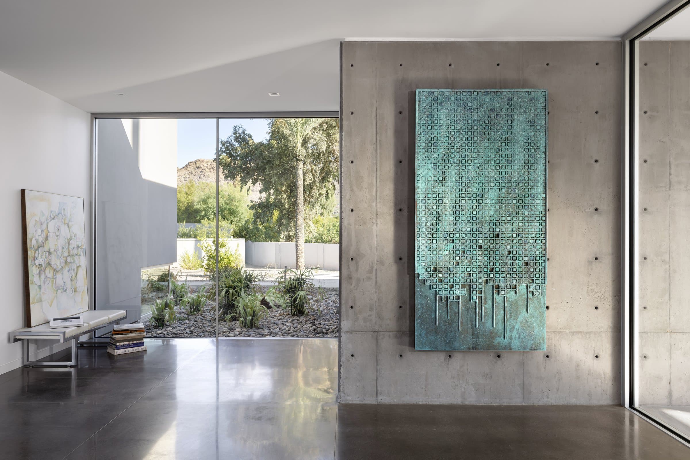 The entry, a pivot door beside a large artwork