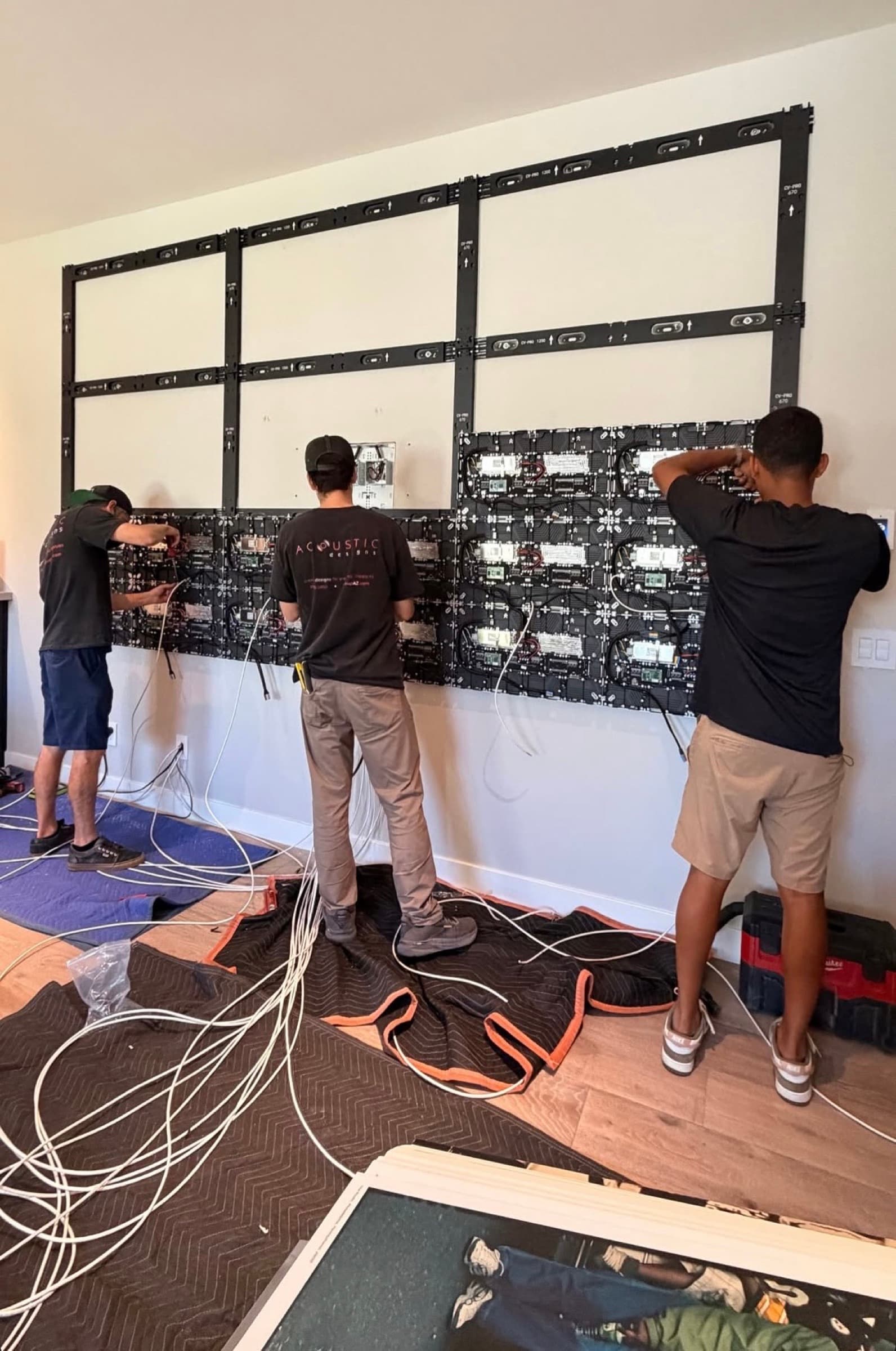 The crew mounting LED tiles onto the video wall frame