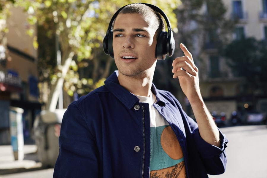 A man in the street wearing stylish headphones.