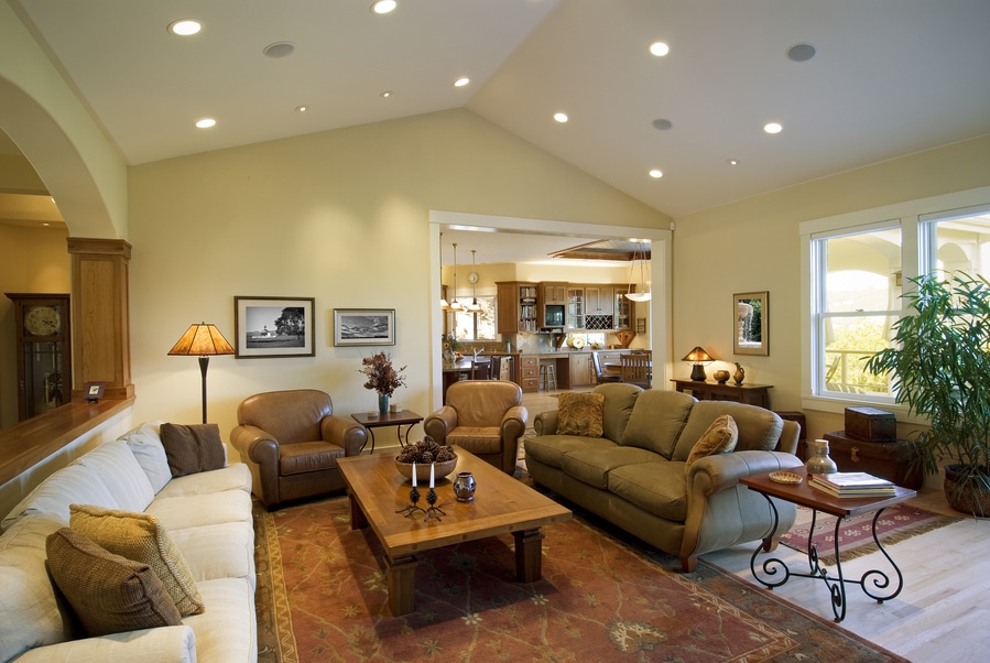 A photo of a luxury living room that includes recessed lighting in the ceiling of the plush and roomy space.