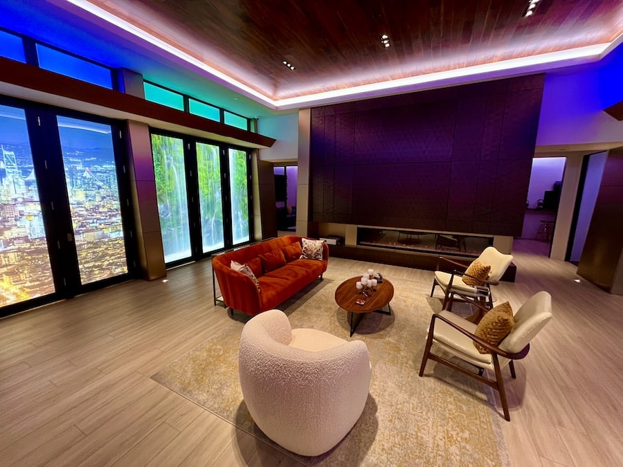 A modern living room in Phoenix, AZ, with ambient lighting and a large hidden TV panel closed.